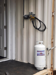 when done, the four propane tanks will be here, strapped to the wall, and individually hooked up to the harness that will feed propane over the top of the enclosure to the generator.